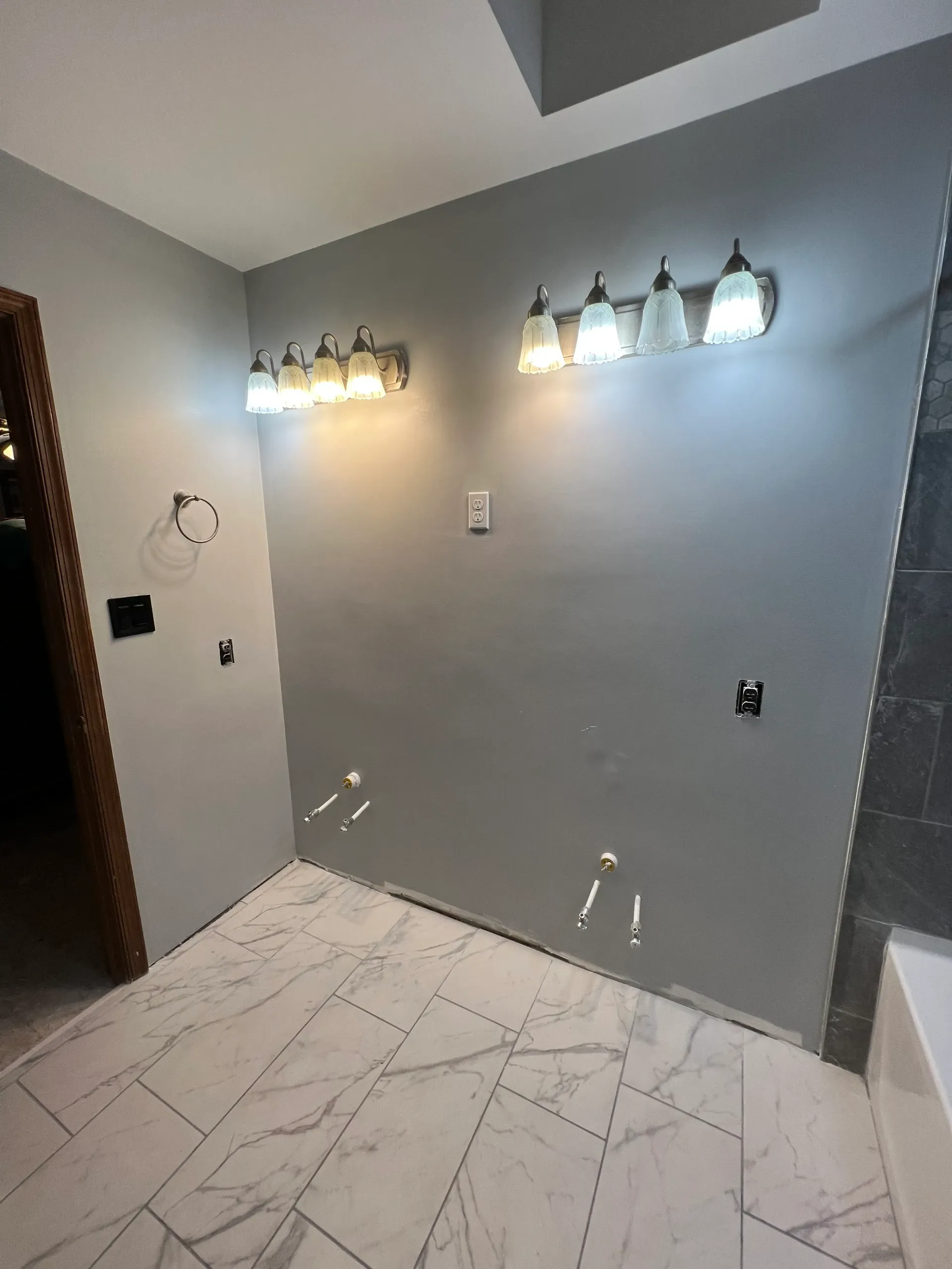 A bathroom with a bathtub and a vanity light.