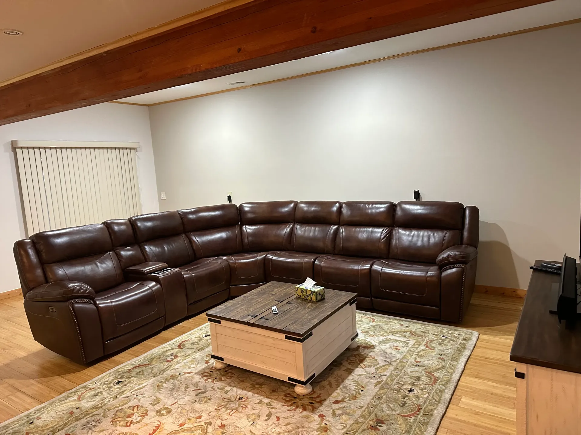 A living room with a large sectional couch and a coffee table.