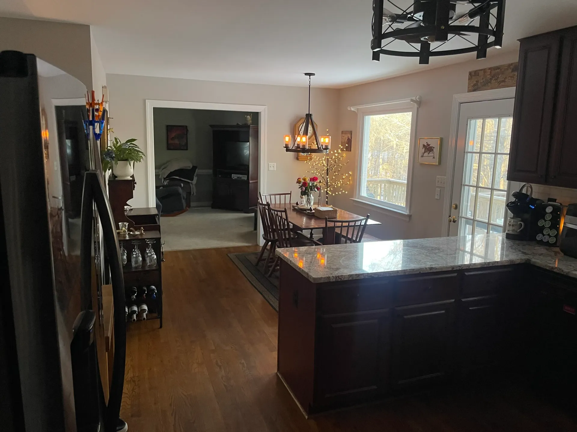 A kitchen with a table and chairs in it and a chandelier hanging from the ceiling.