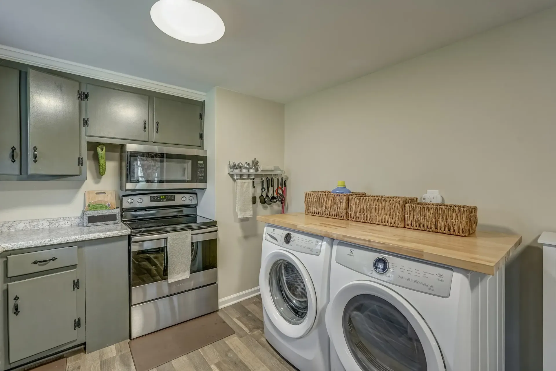 A laundry room with a washer and dryer and a microwave.