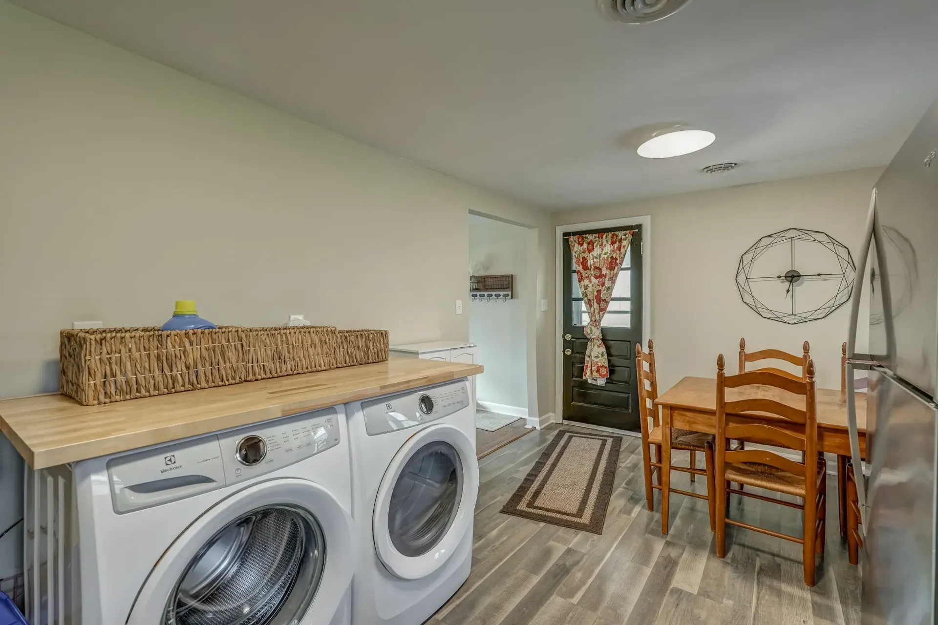 A laundry room with a washer and dryer and a table and chairs.