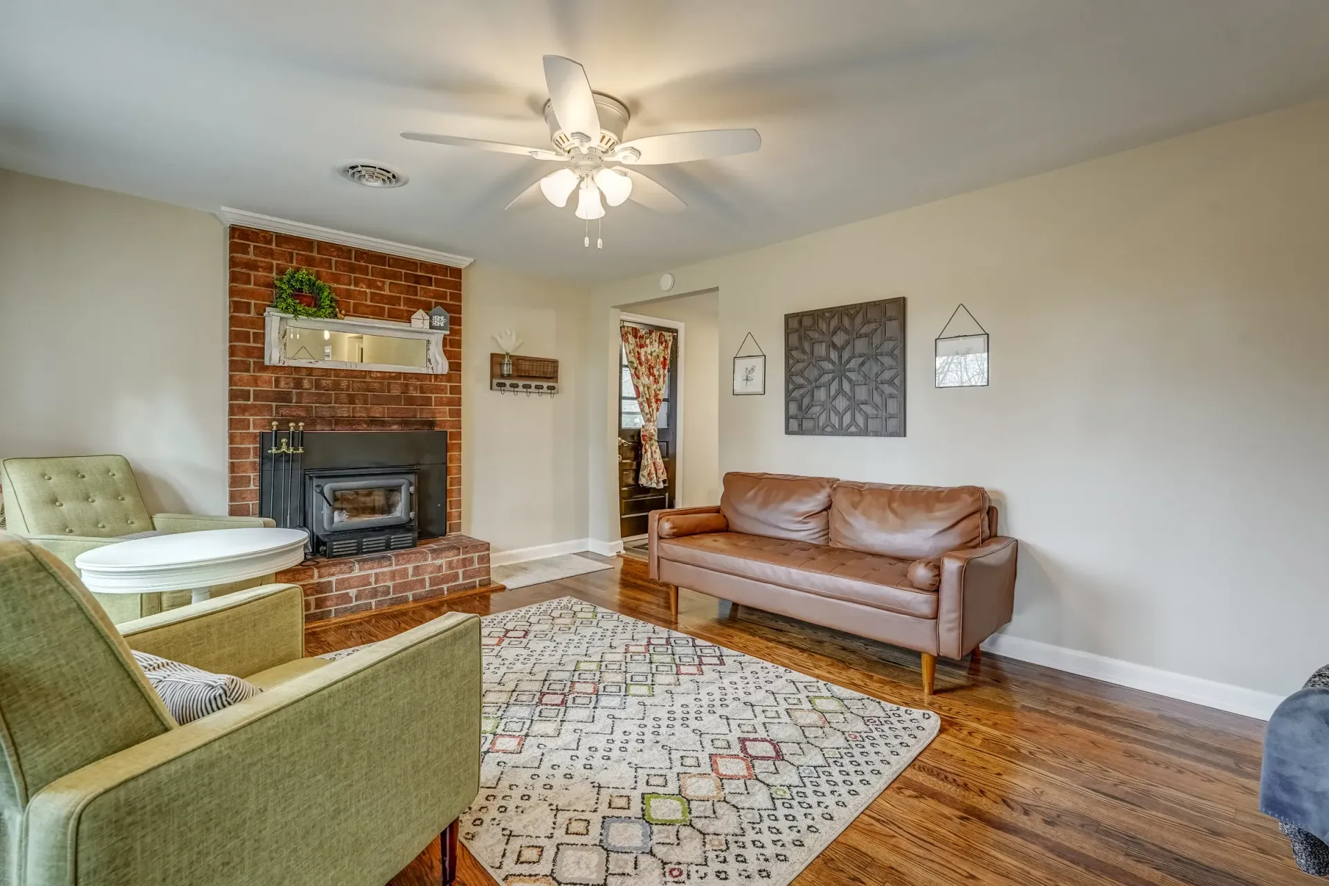 A living room with a couch , chairs , and a fireplace.