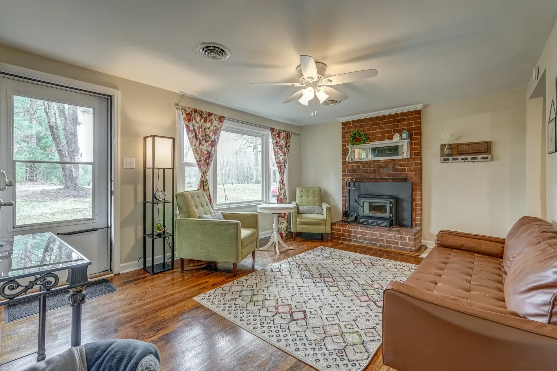 A living room with a couch , chairs , table and fireplace.