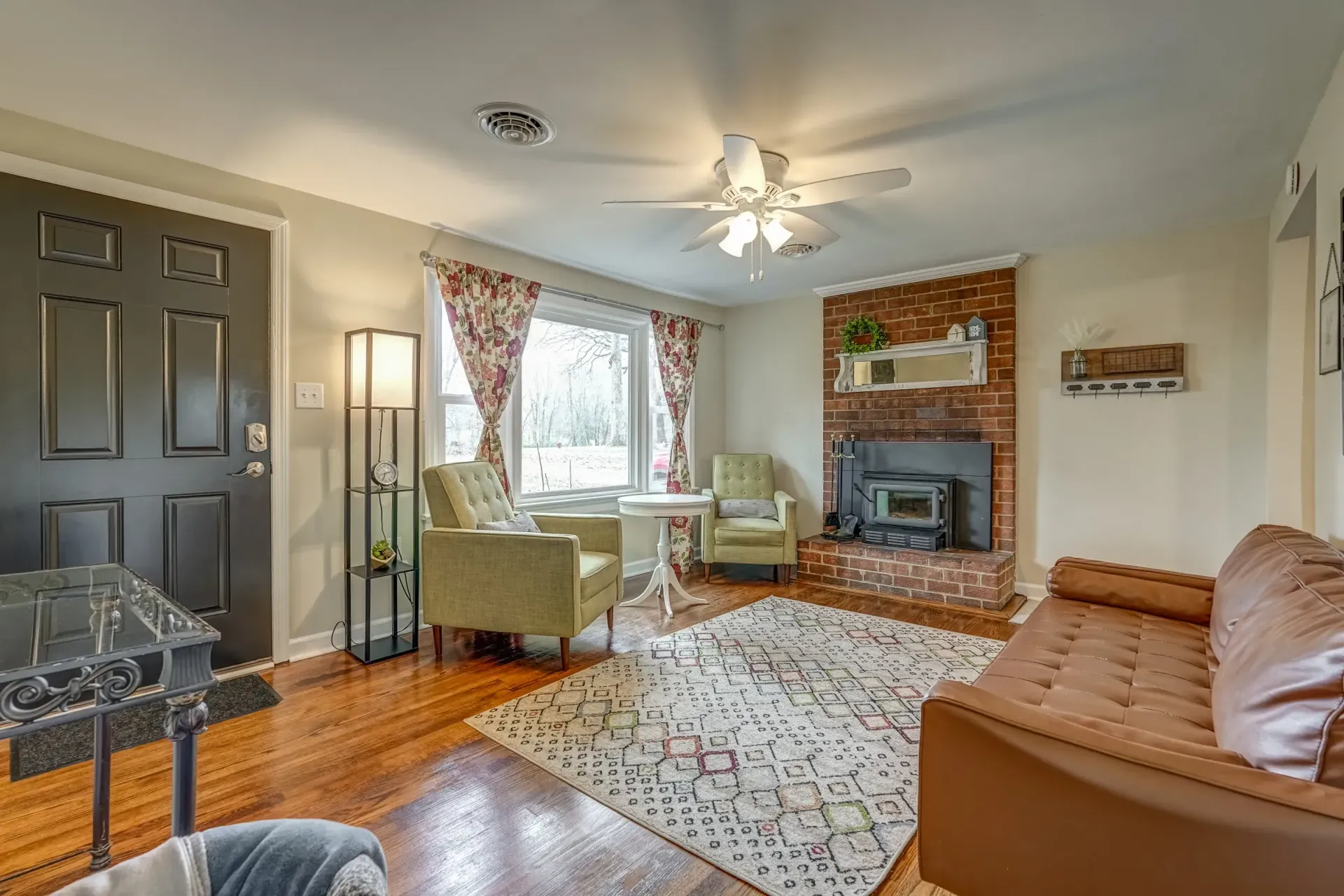 A living room with a couch , chairs , table and fireplace.