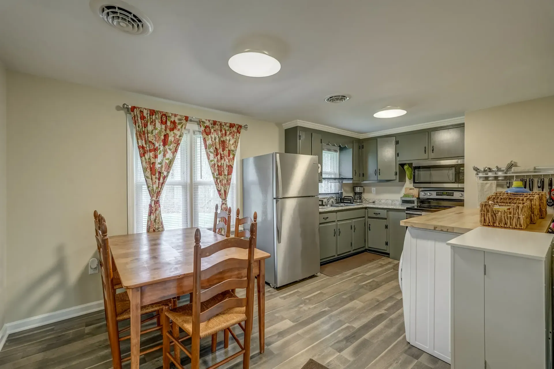 A kitchen with a table and chairs and a refrigerator.