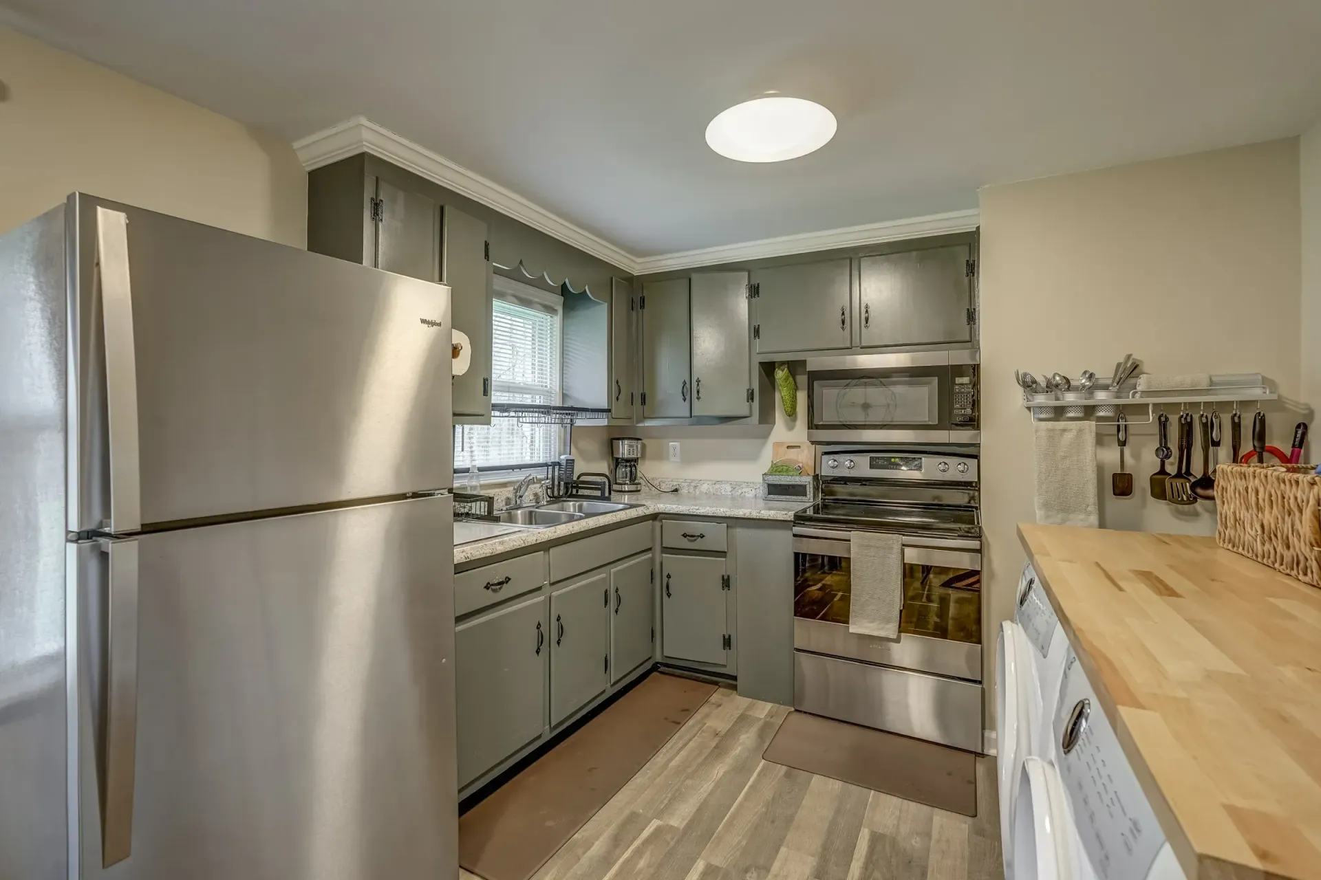 A kitchen with stainless steel appliances and gray cabinets