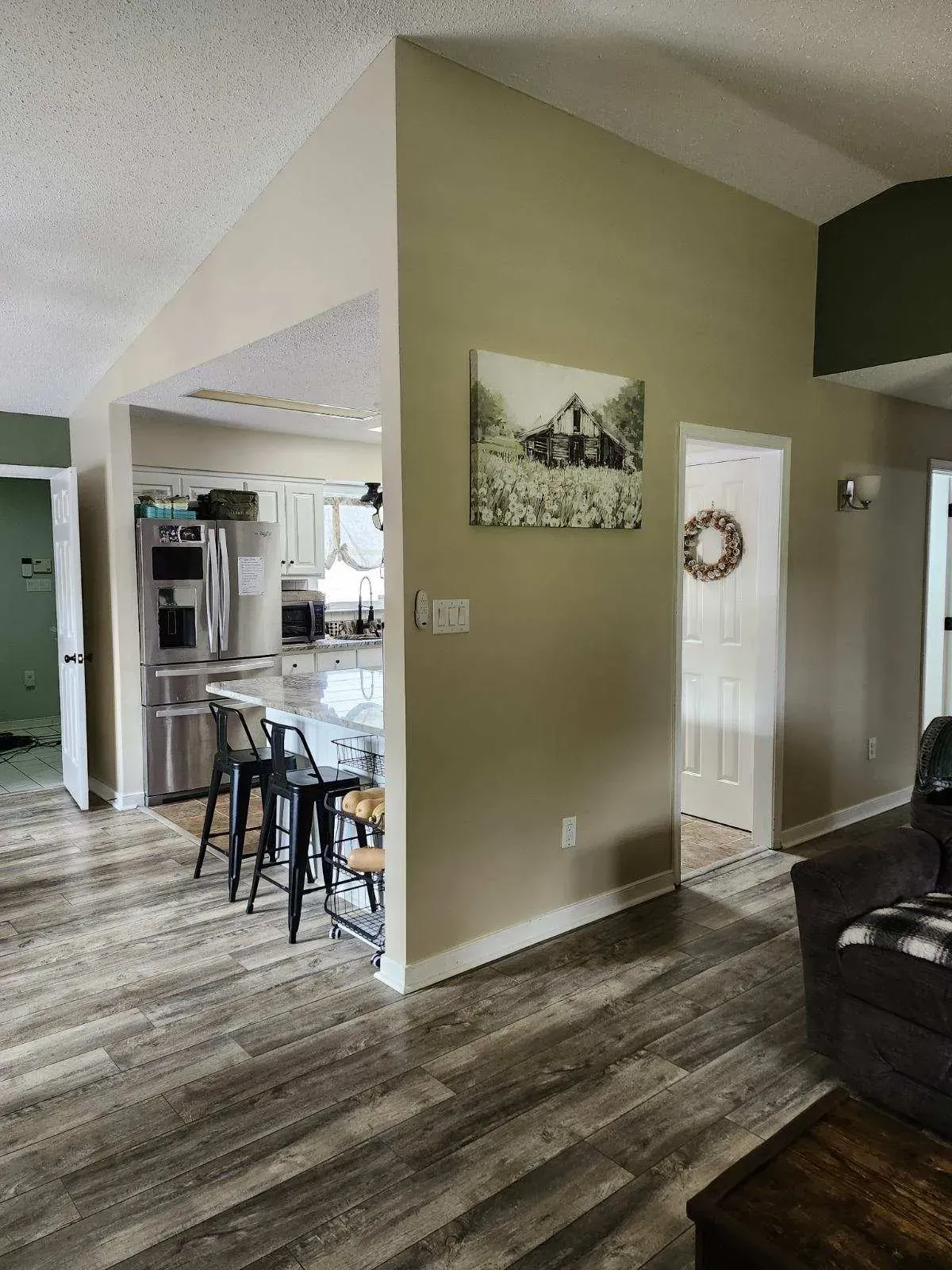 A living room with hardwood floors and a painting on the wall.
