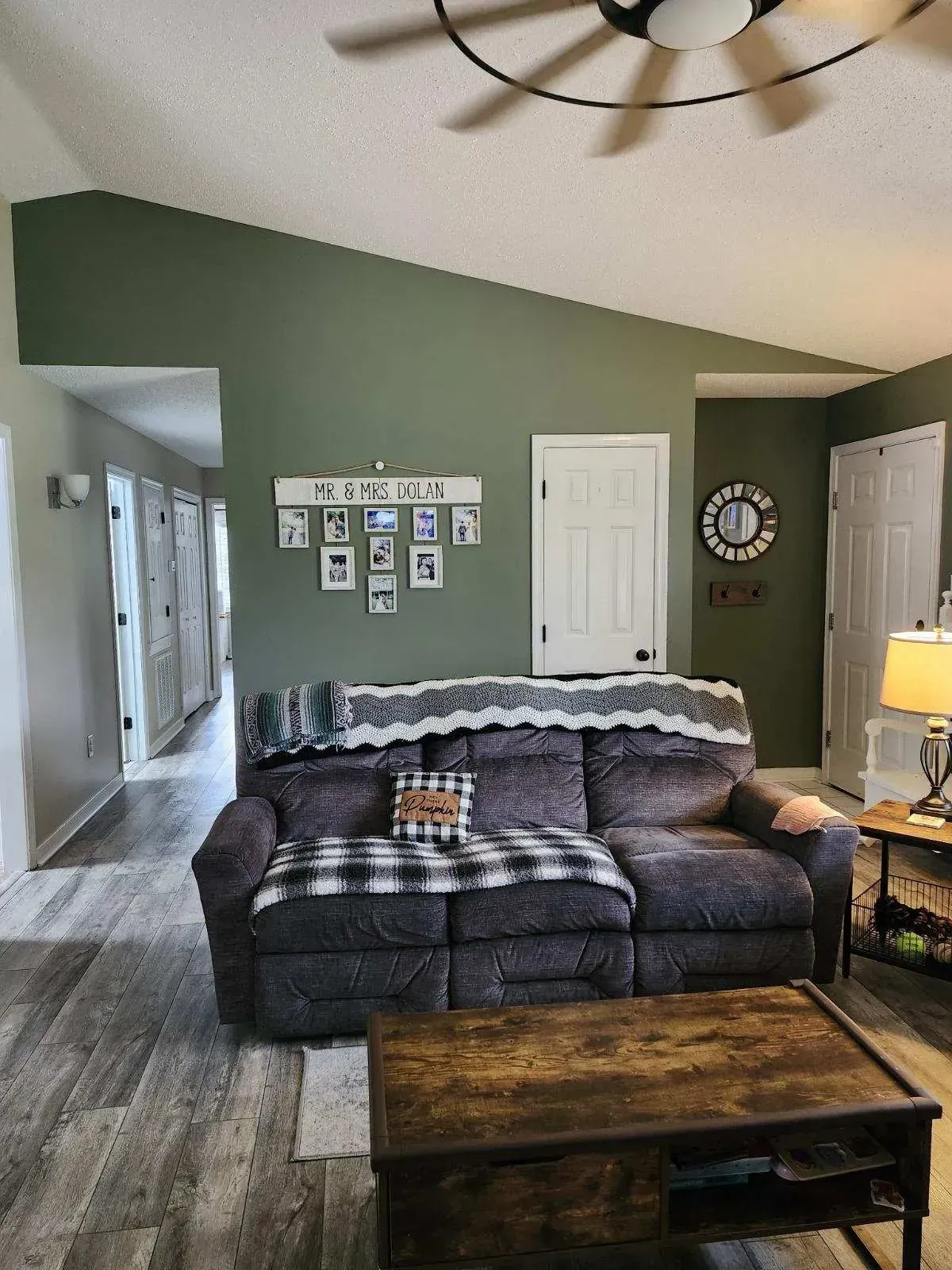 A living room with a couch , coffee table , and ceiling fan.