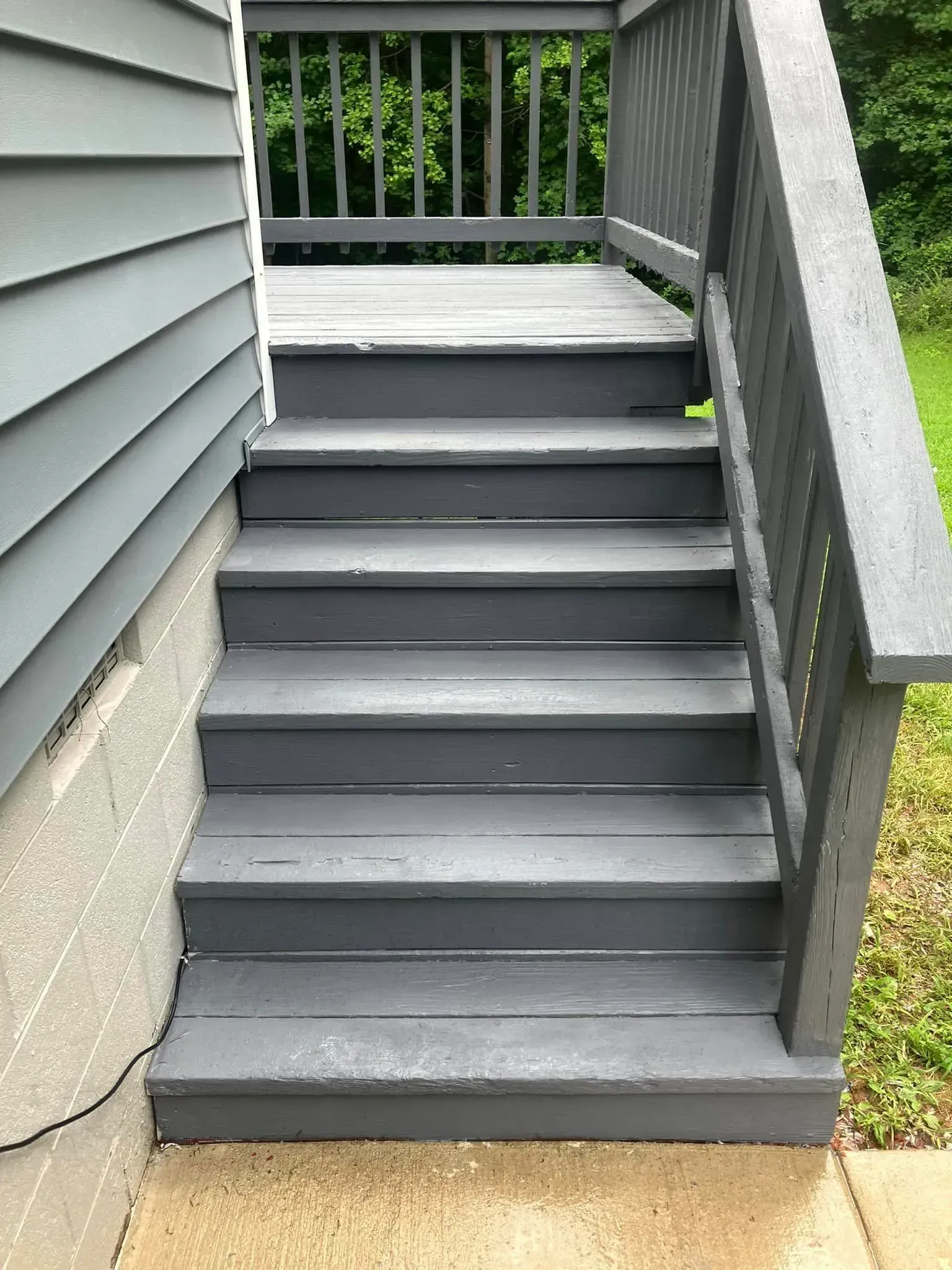 A set of stairs leading up to a deck on the side of a house.