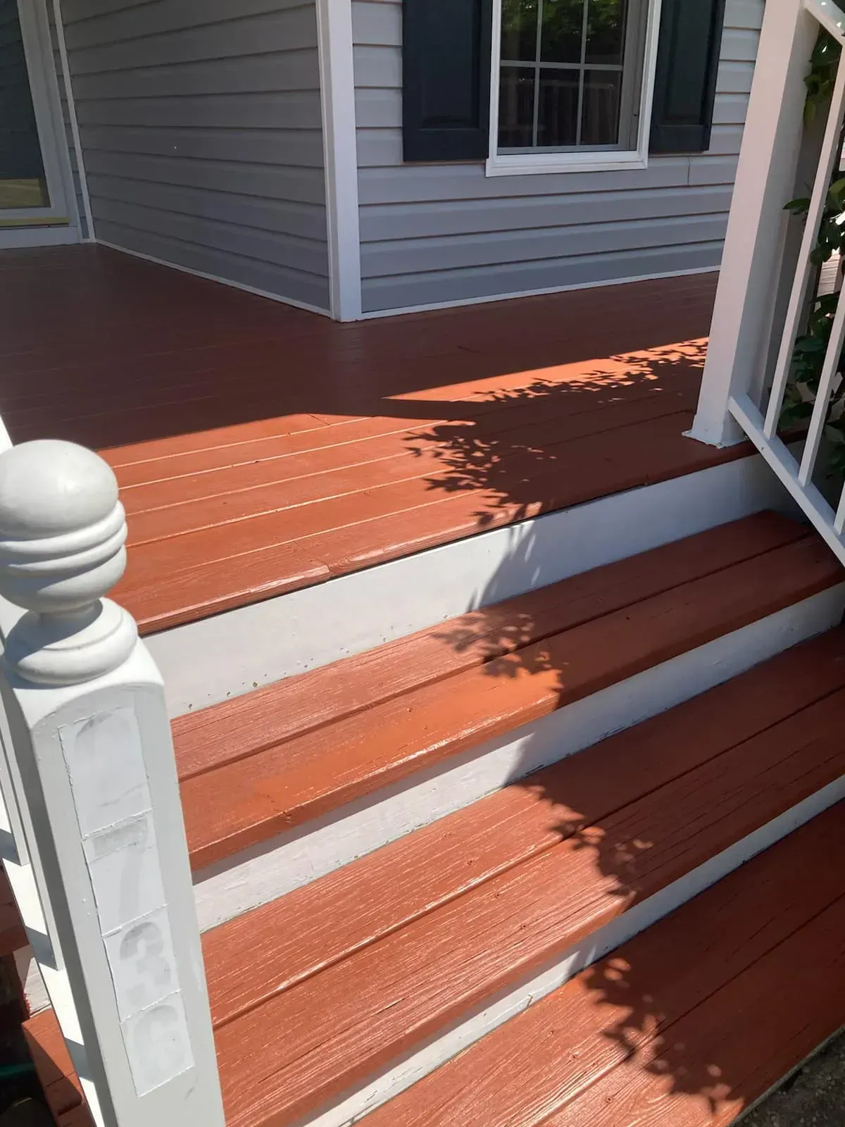A wooden deck with stairs leading up to a house.
