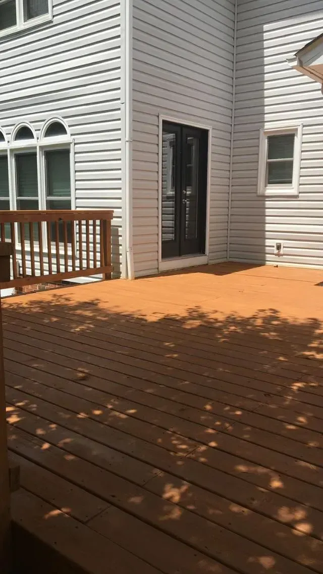 A large white house with a wooden deck in front of it.