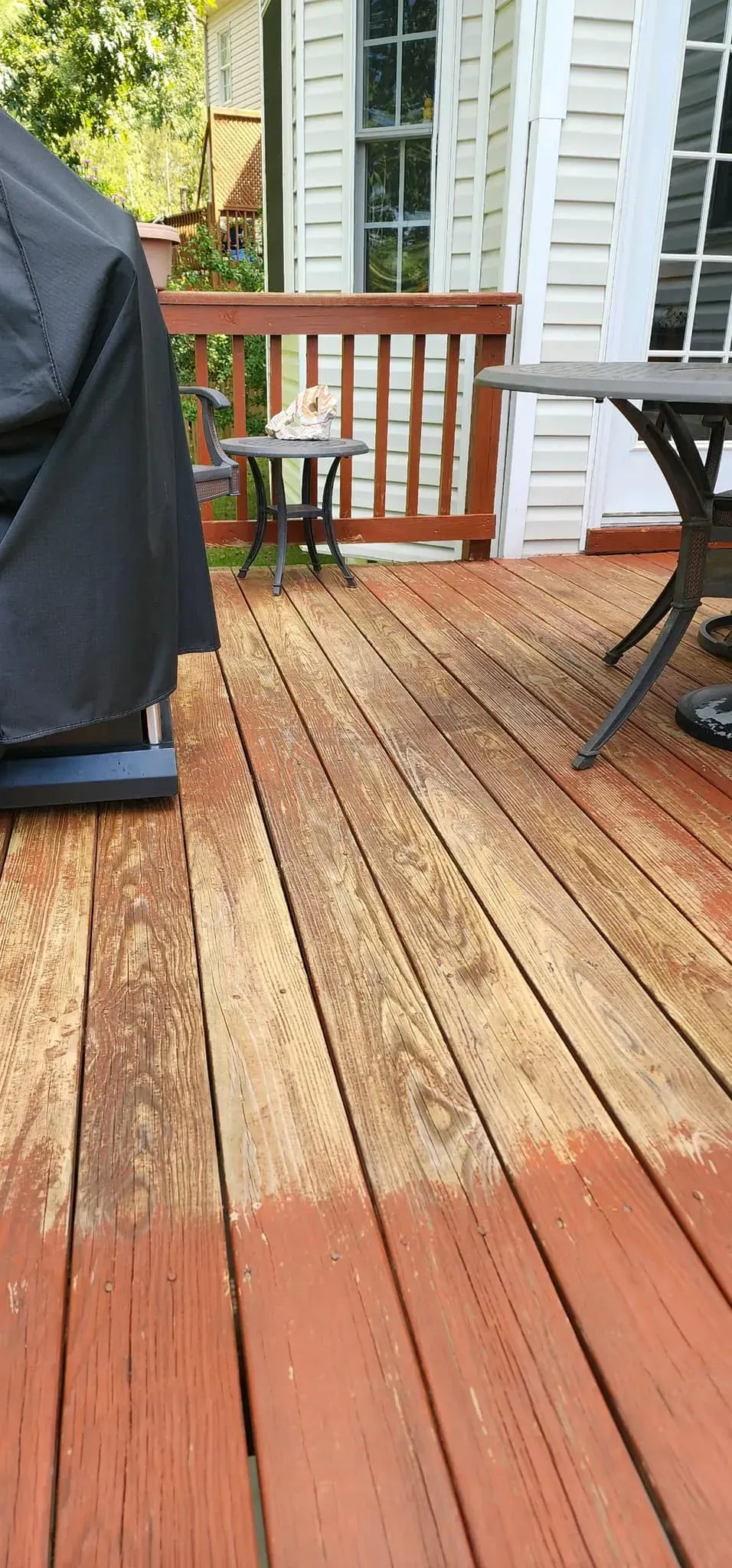 A wooden deck with a grill and a table on it.