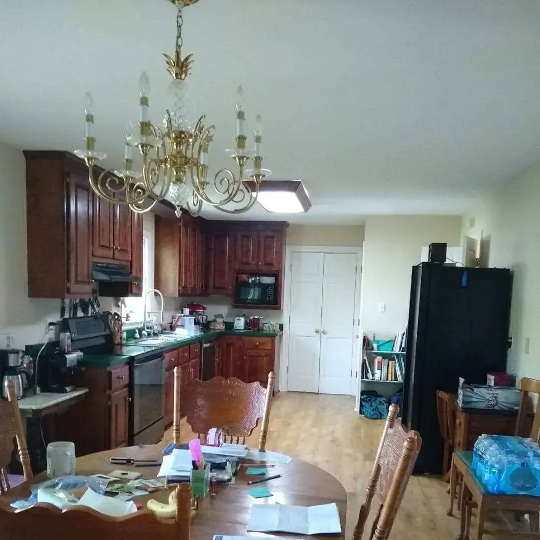 A kitchen with a table and chairs and a chandelier hanging from the ceiling
