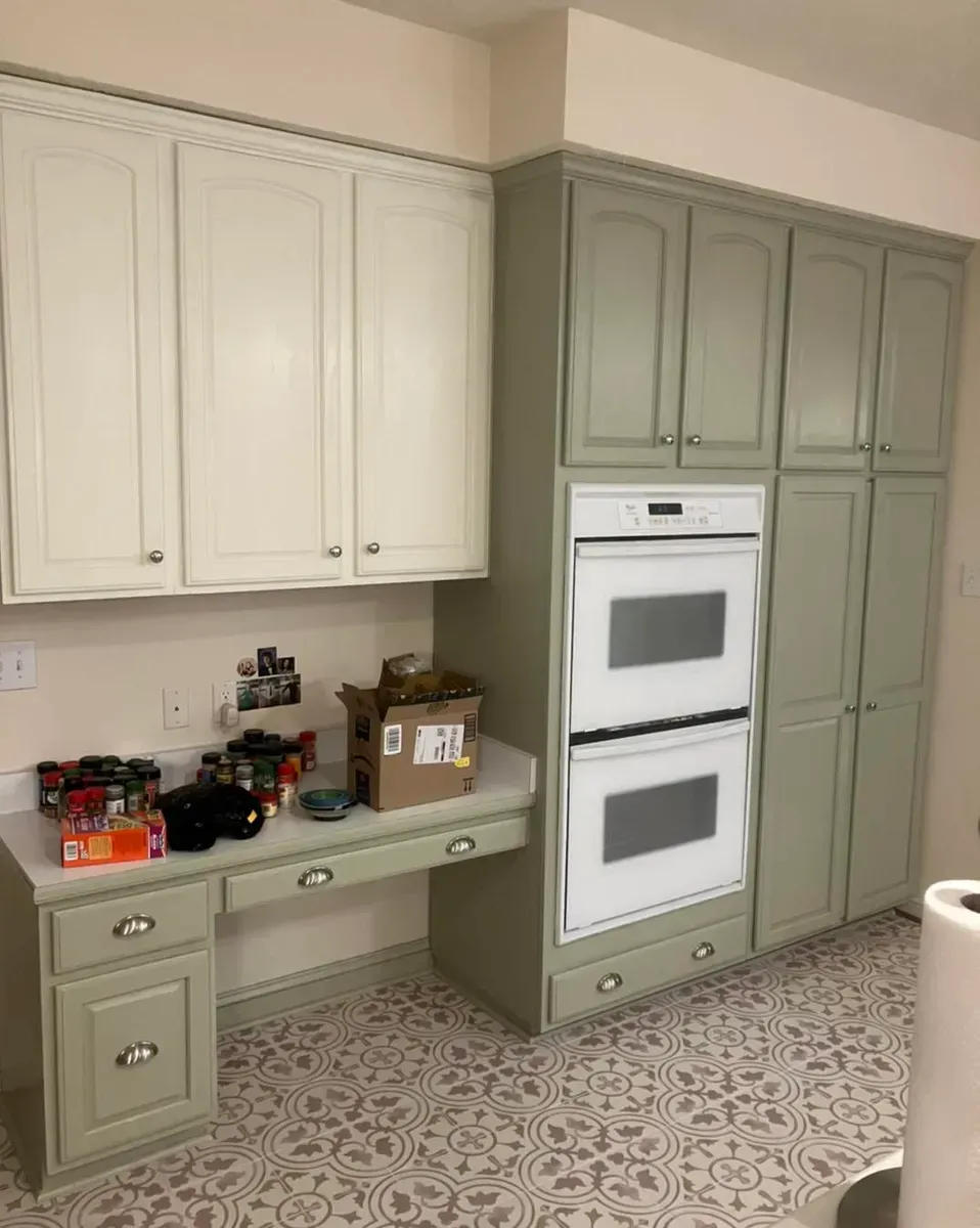 A kitchen with green cabinets and a white oven