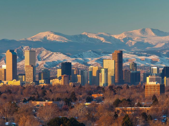 A city skyline with snowy mountains in the background