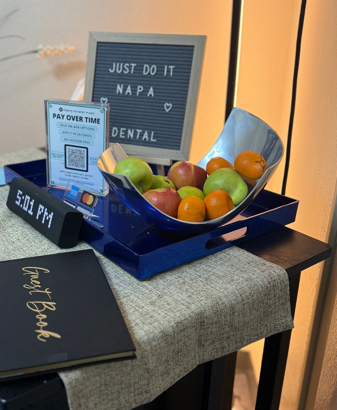 Fruit bowl with apples and oranges on a tray, letter board with 