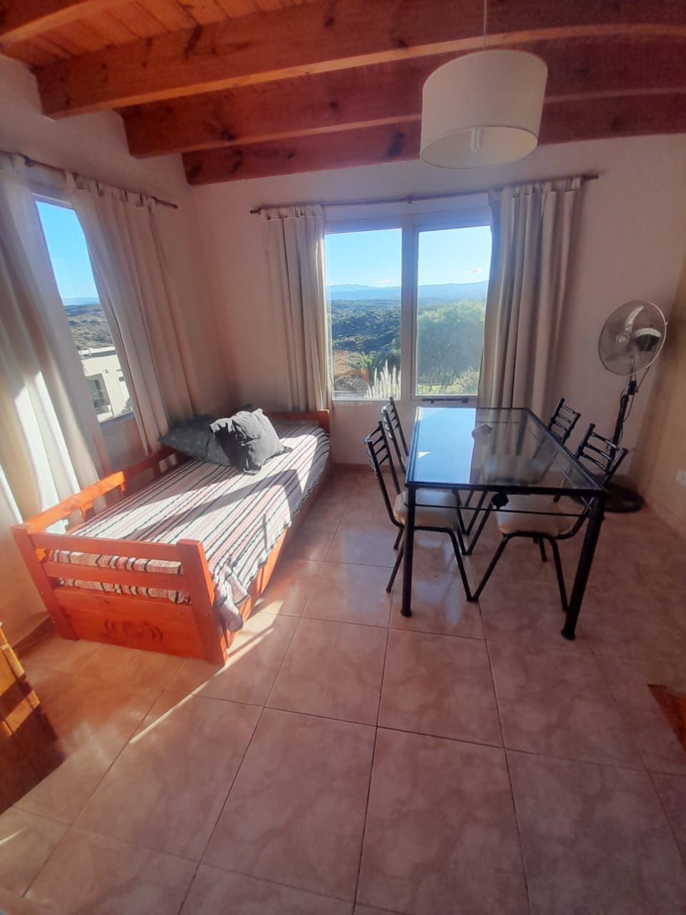 Cocina pequeña con estufa, microondas, fregadero y refrigerador. Luminosa y con ventana.