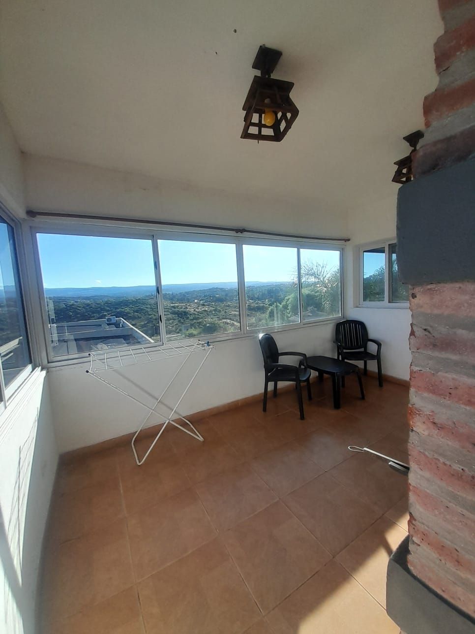 Escaleras de madera que conducen a un área tipo loft con un dormitorio visible más allá de una barandilla.