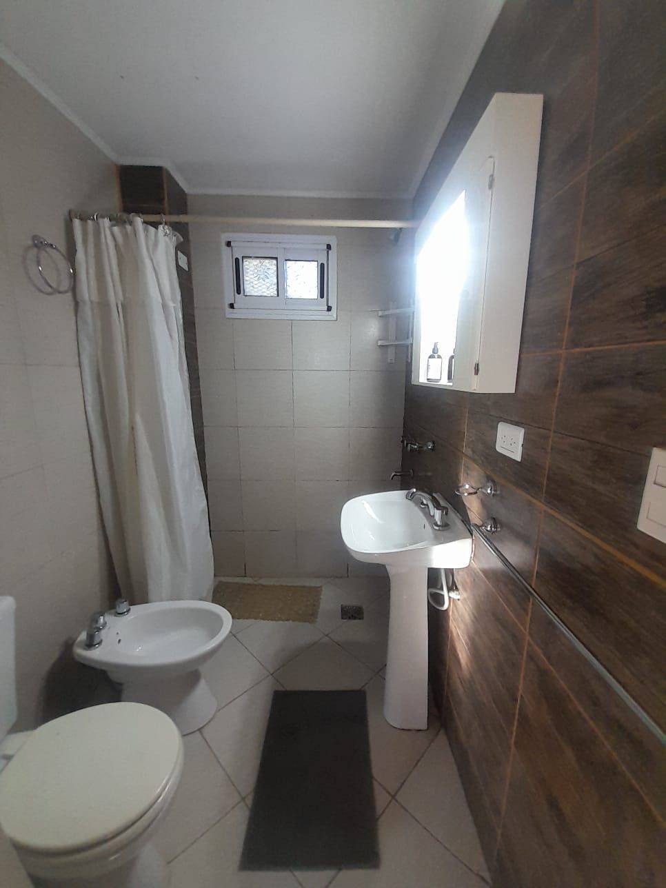 Cocina con techo de madera, gabinetes blancos y mesa de comedor con sillas.