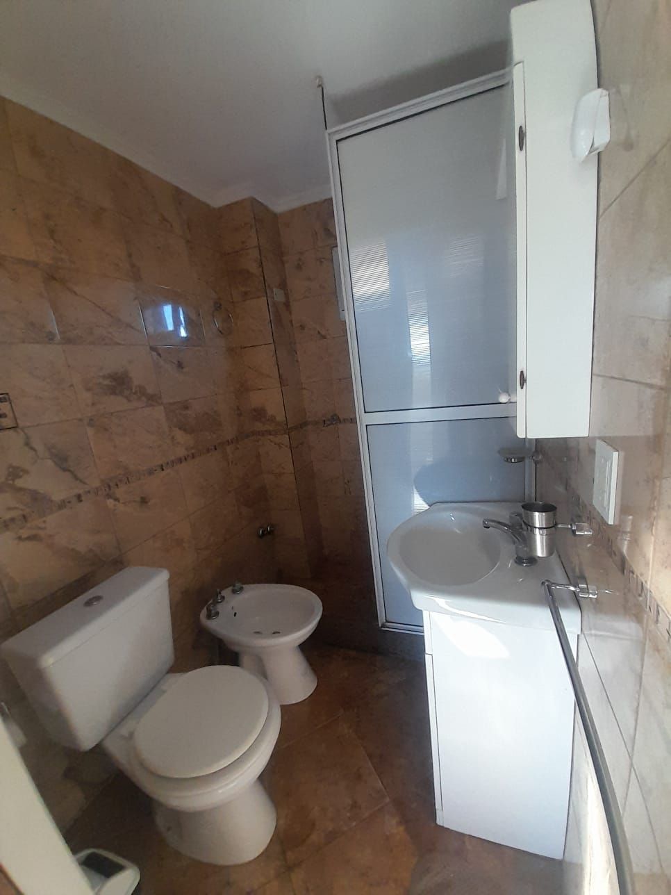 Dormitorio con cama, mesitas de noche, ventana y techo de madera.