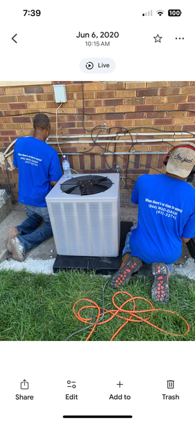 A woman is sitting on a couch in front of a fan.