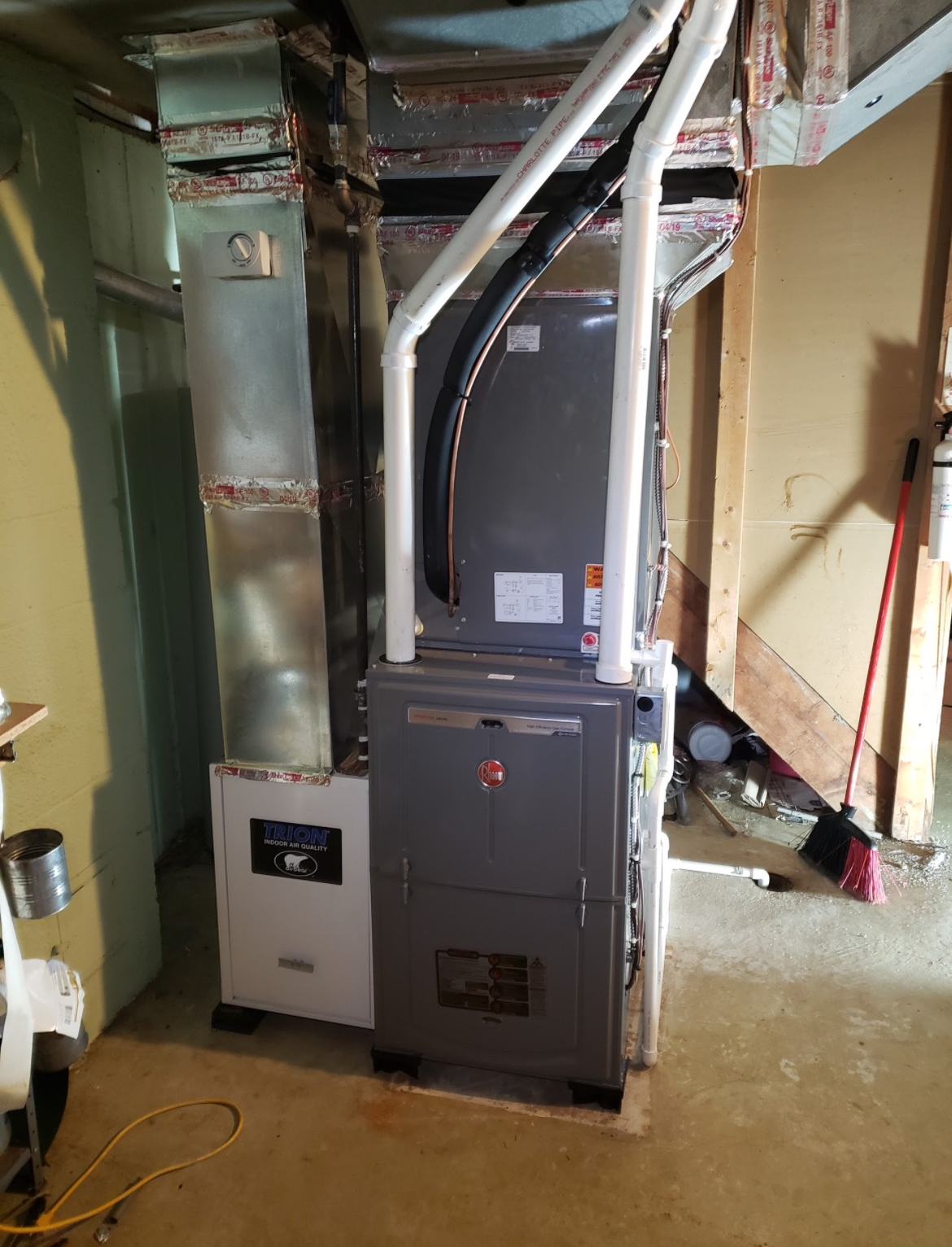 Construction workers on ladders inside a building. One worker is high up. Other worker is below.