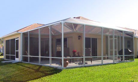 Sand colored house with enclosure with grill inside — Leesburg, FL — Aluminum Contractors Inc