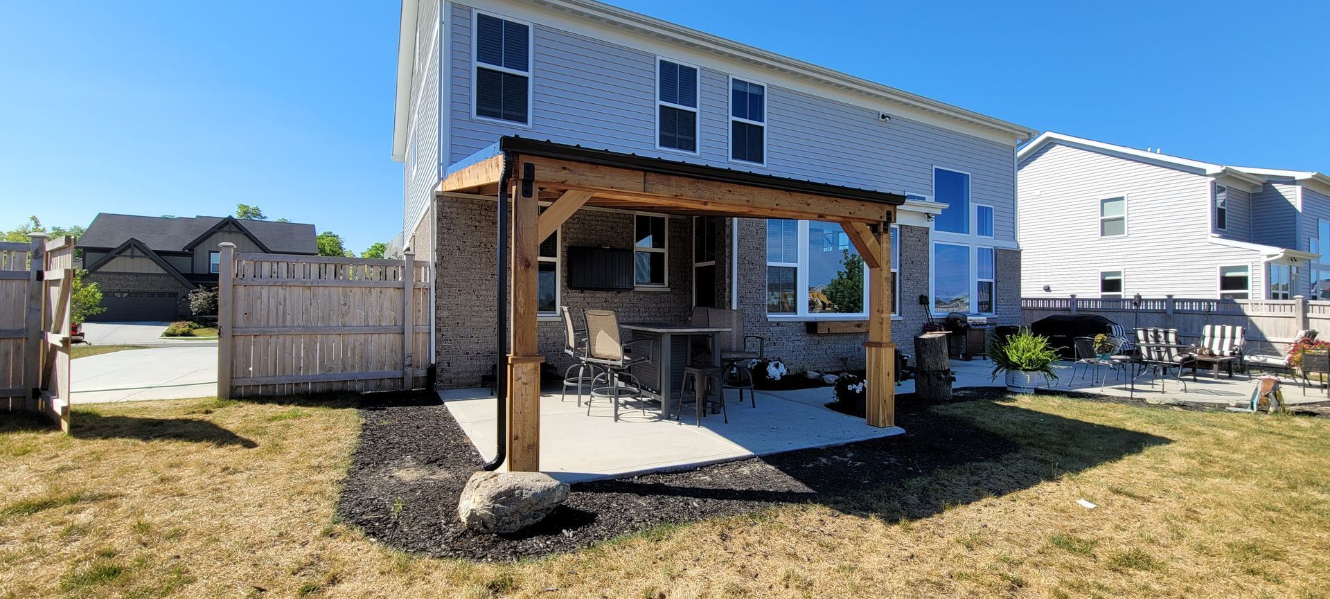 There is a pergola in the backyard of a house .