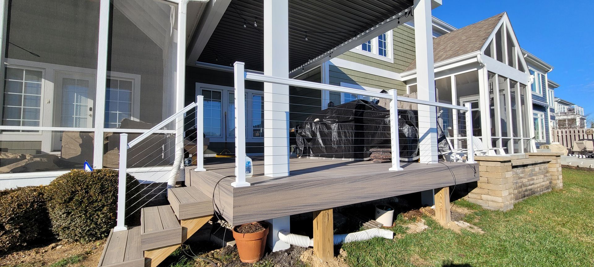 A house with a screened in porch and stairs leading to it .