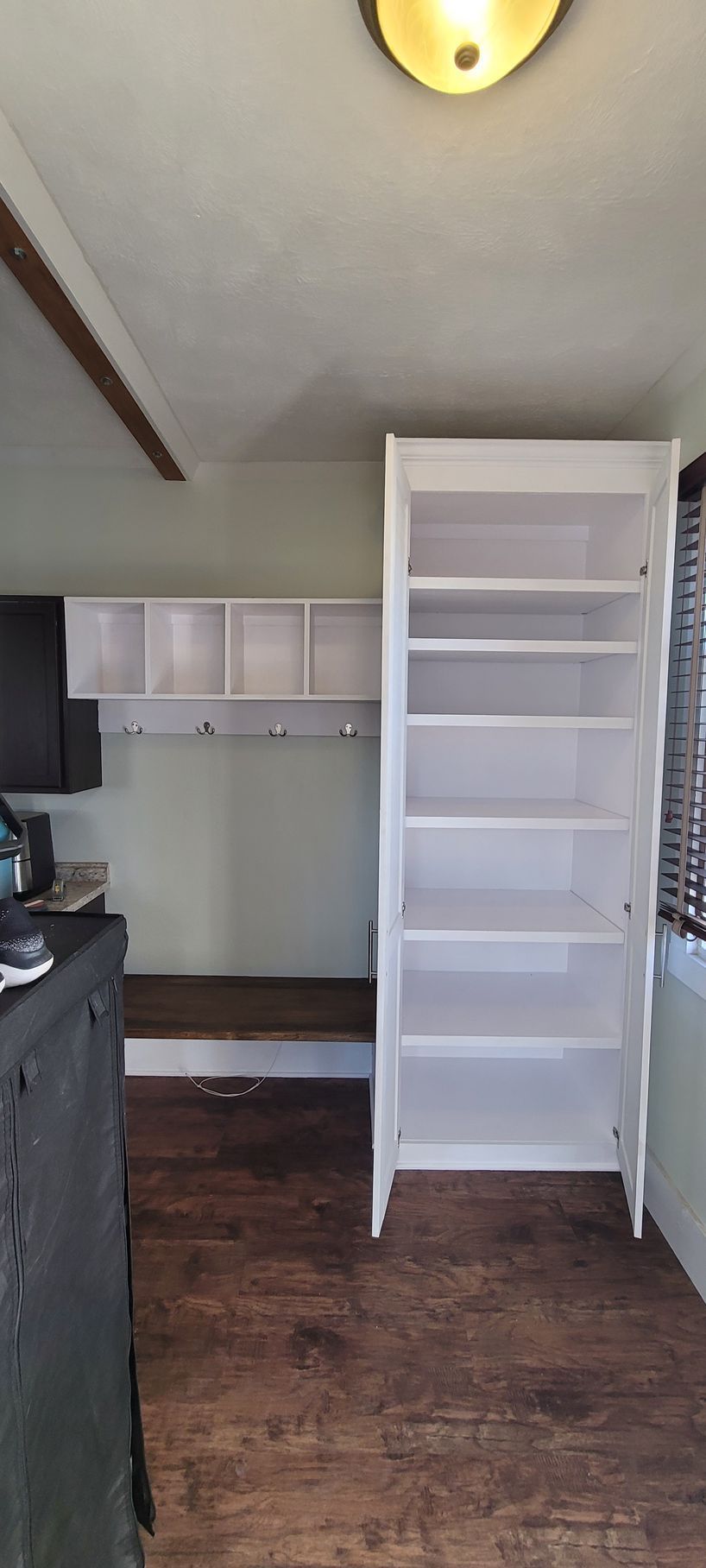 A room with a lot of shelves and a window .