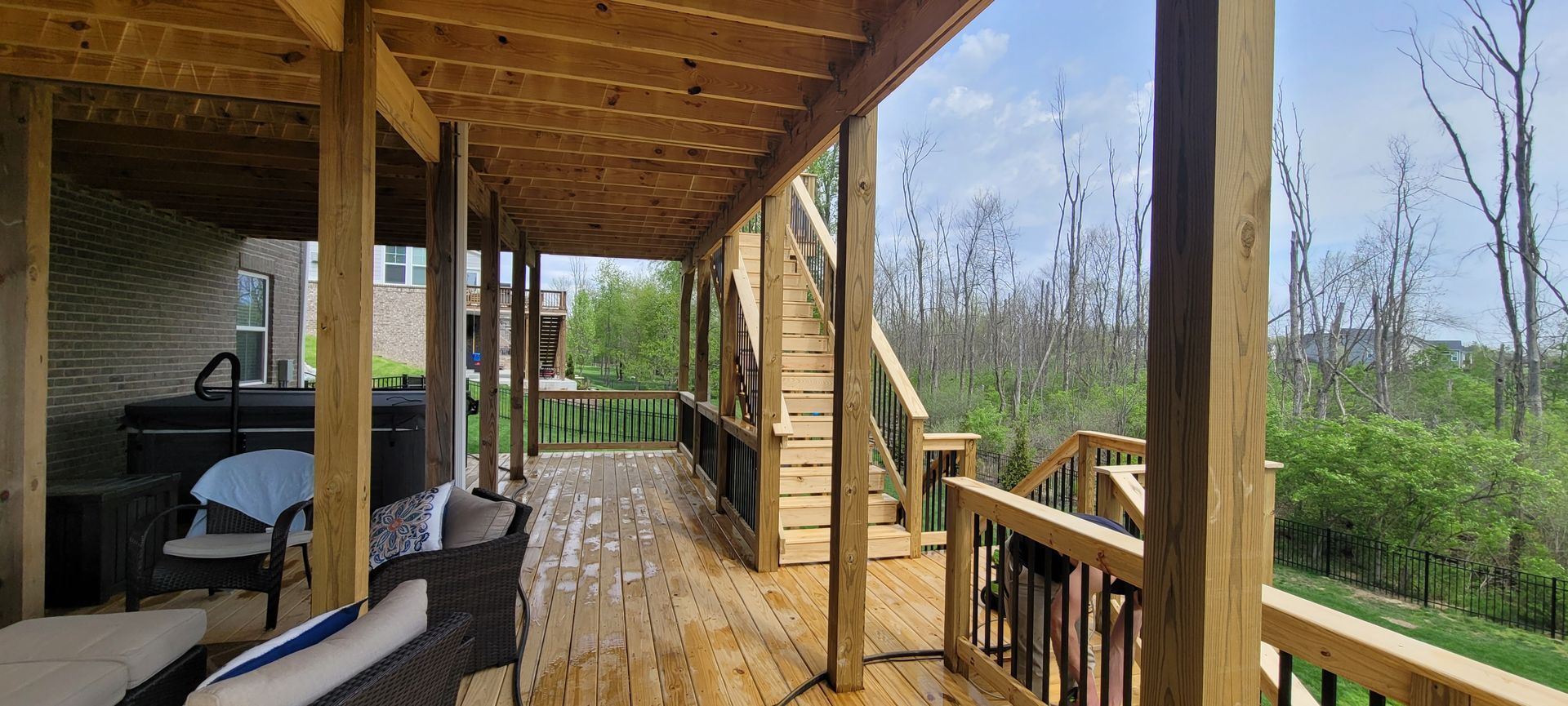 A large wooden deck with a gazebo and stairs leading up to it .