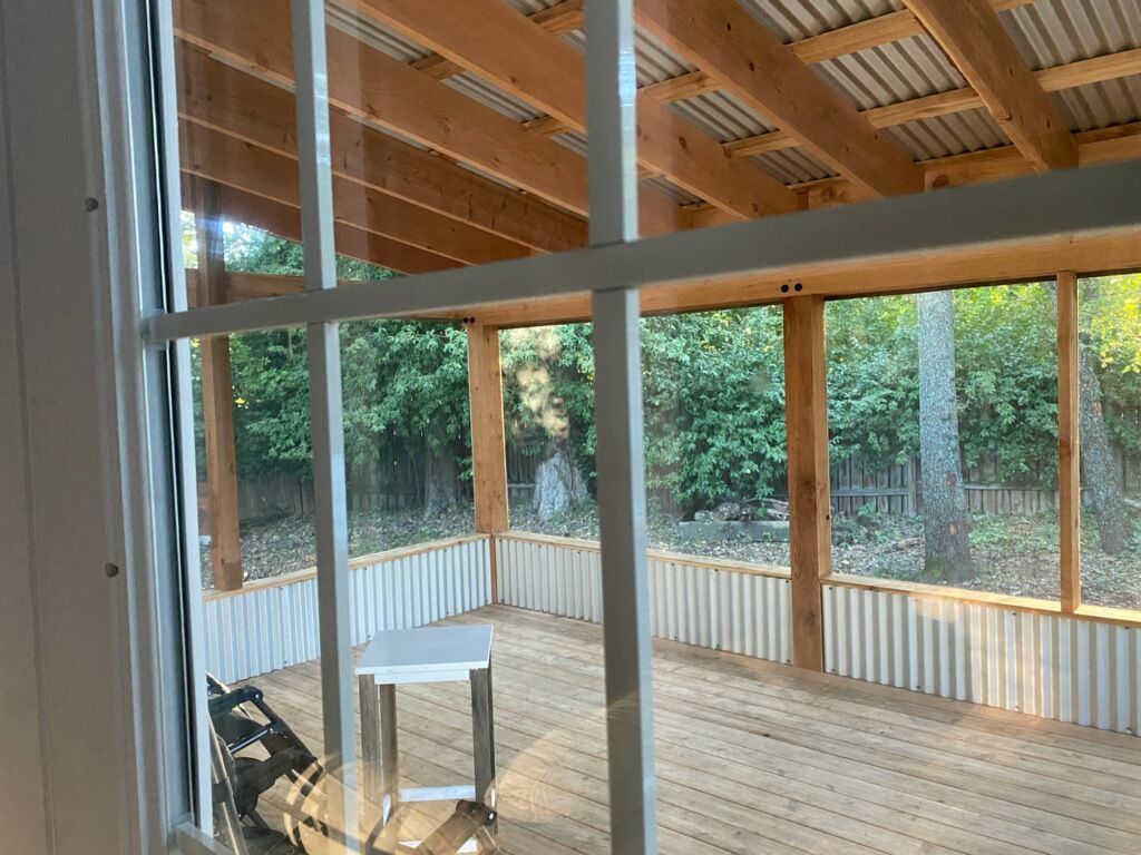 A screened in porch with a table and chairs .