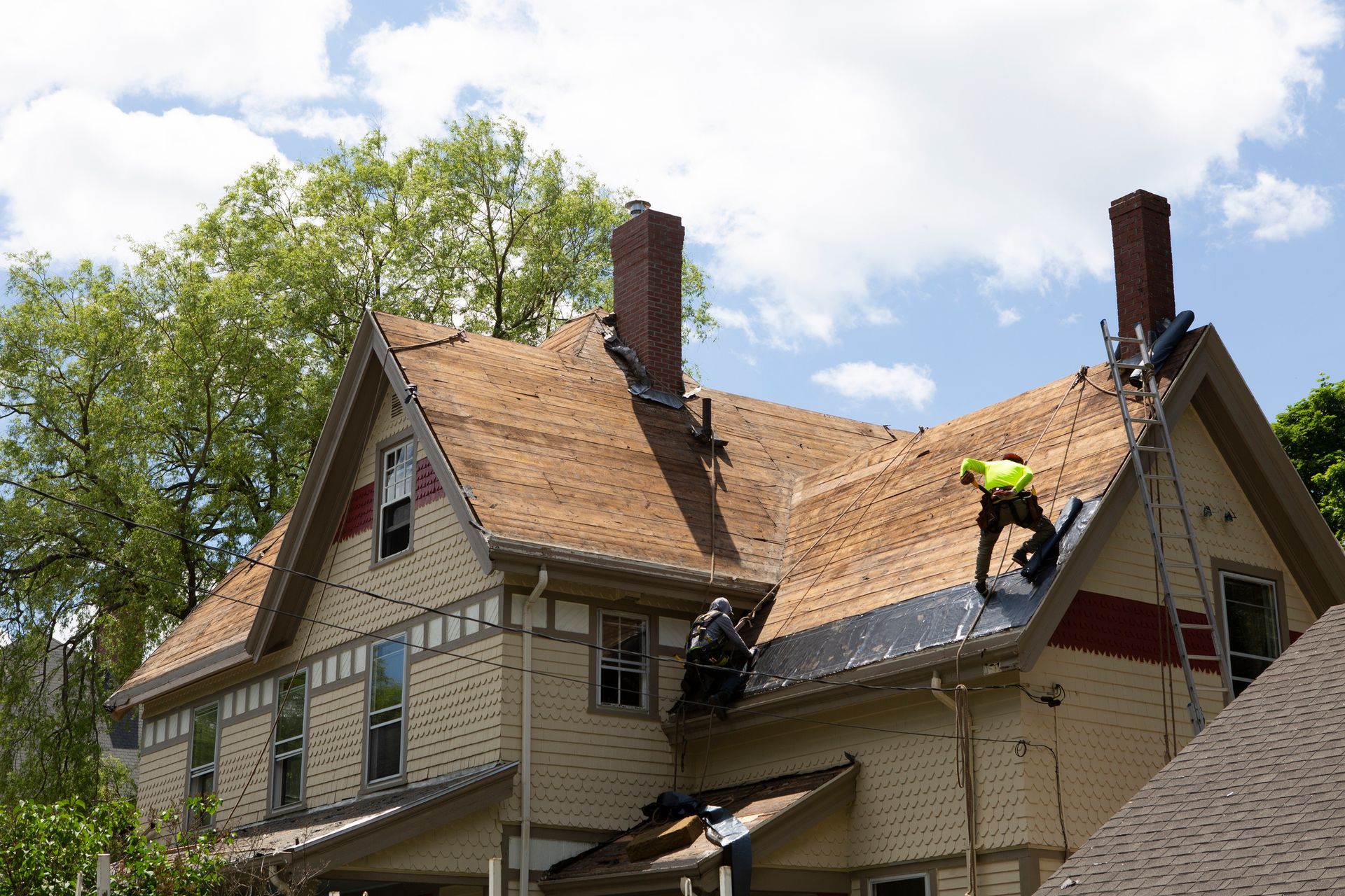 A contractor performing a roofing system replacement, carefully installing new materials on a roof.