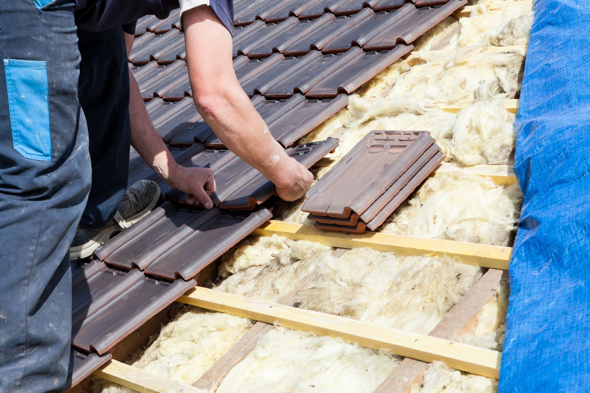 A man on a ladder working on a roof, focused on a roofing system replacement project. A man on a ladder working on a roof, focused on a roofing system replacement project.