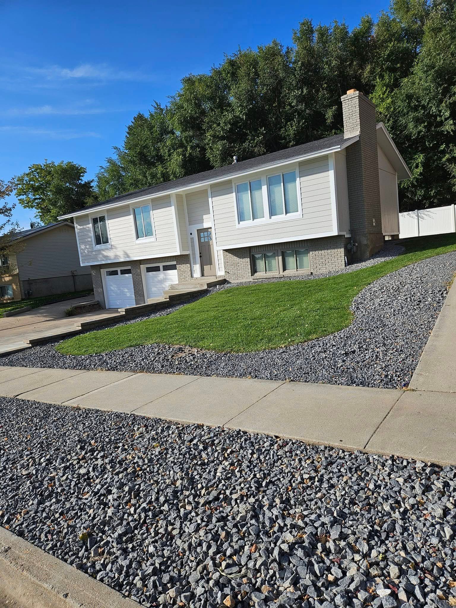A white house with a gravel driveway in front of it