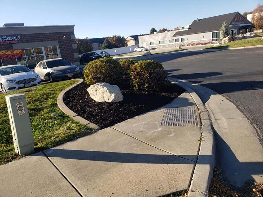 A sidewalk with a rock in the middle of it