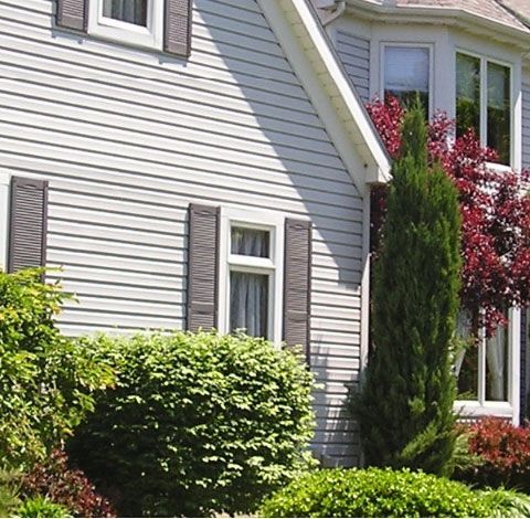 A white house with brown shutters on the windows