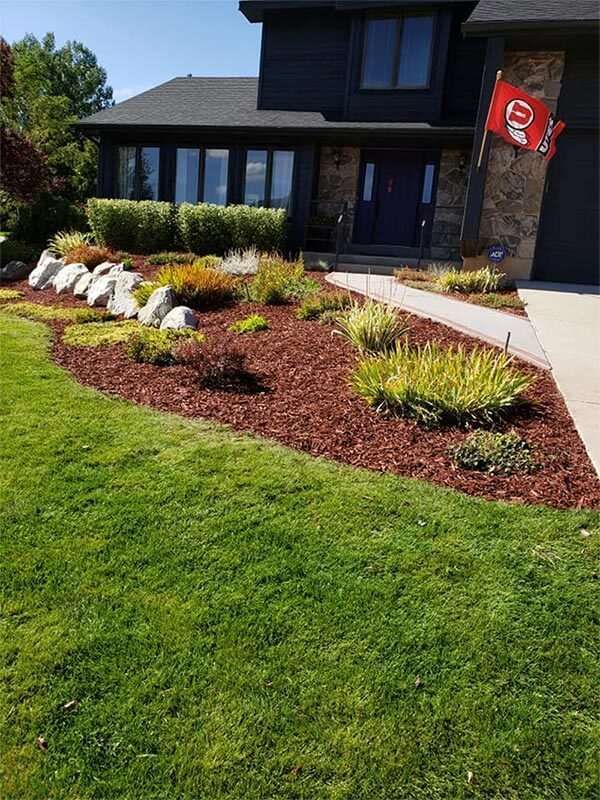 A large house with a lush green lawn and a flag in front of it.