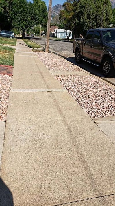 A sidewalk with a truck parked on the side of it.