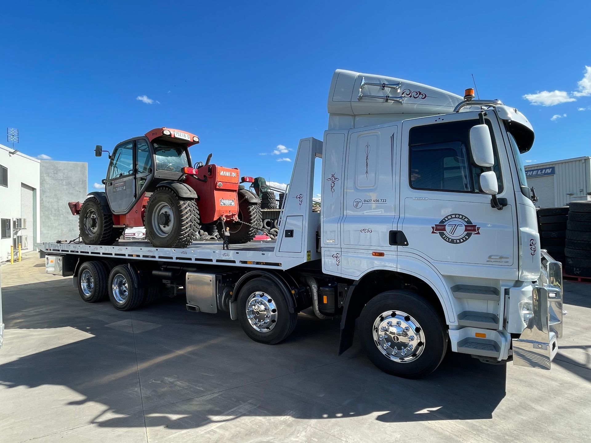 Heavy New Yellow Excavator On Transportation Truck With Long Trailer Platform — Reliable Heavy Machinery in Tamworth, NSW