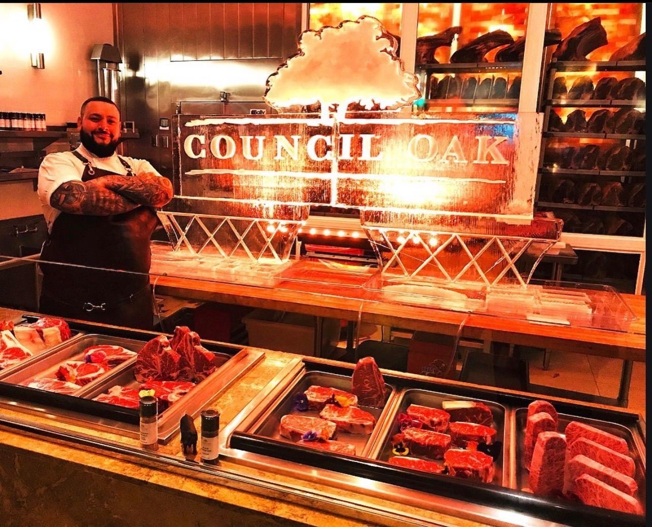 Man Stands in front of a Council Oak Sign