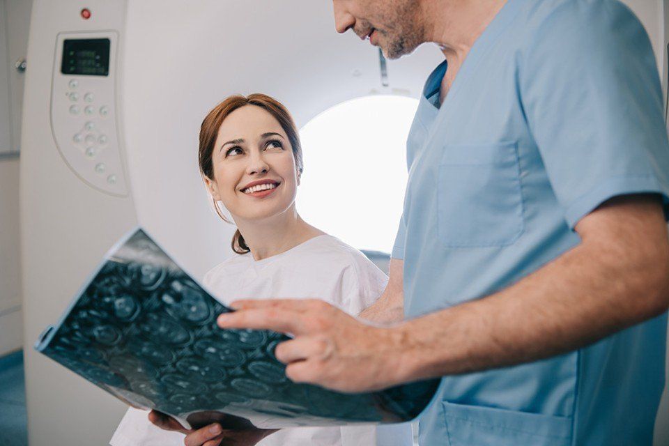 medico mentre mostra una radiografia a una paziente