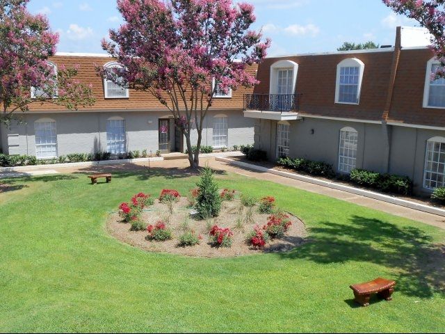 A house with a lush green lawn in front of it