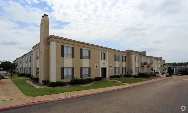 A large apartment building with a chimney on top of it.