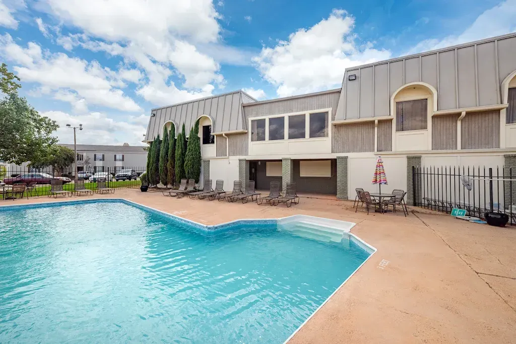 There is a large swimming pool in front of a building.