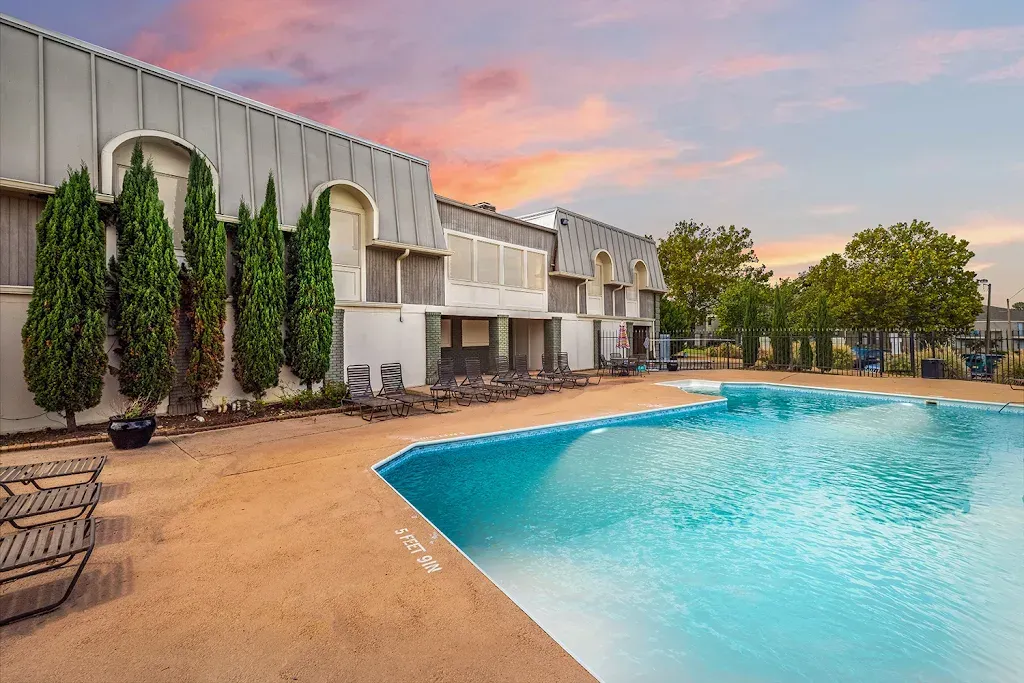 There is a large swimming pool in front of a building.