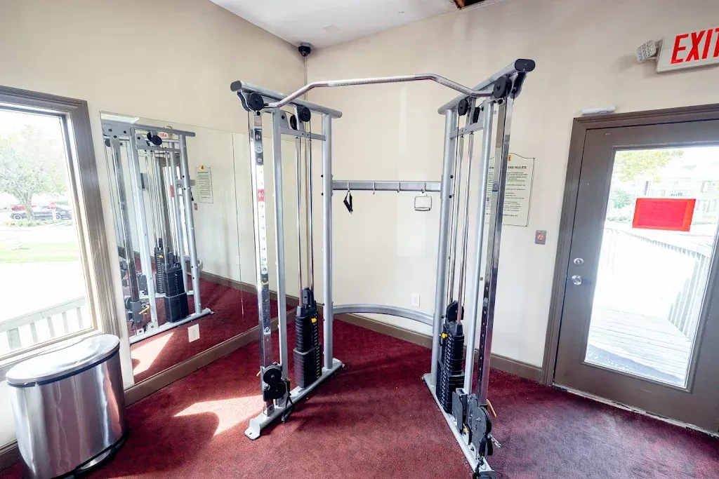 A gym with a red exit sign on the wall