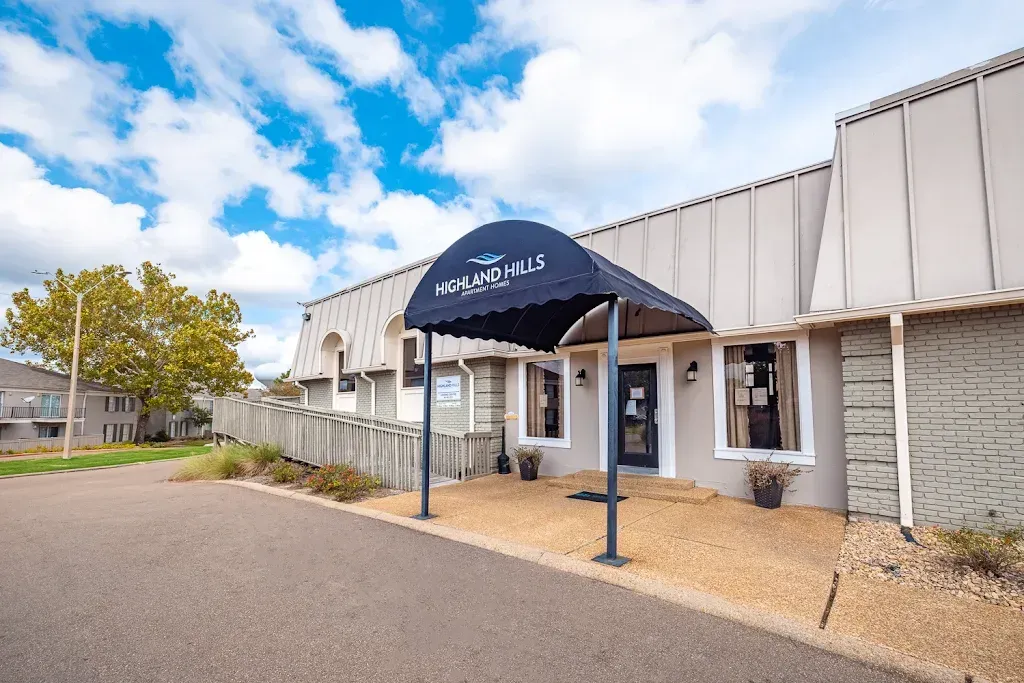 A large white building with a blue awning over the entrance.