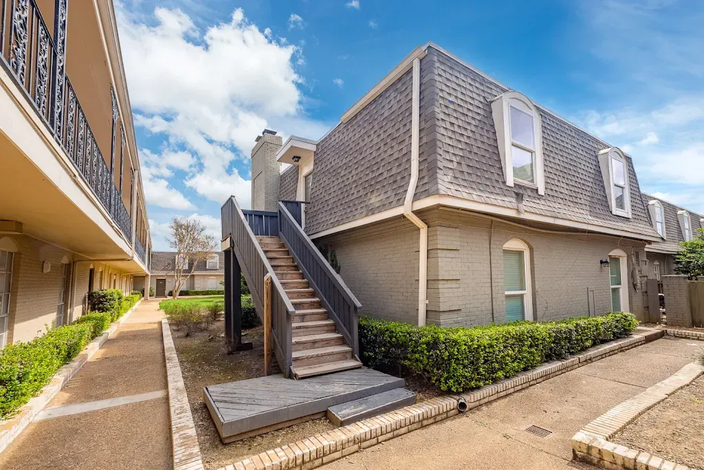 A large apartment building with stairs leading up to the second floor.