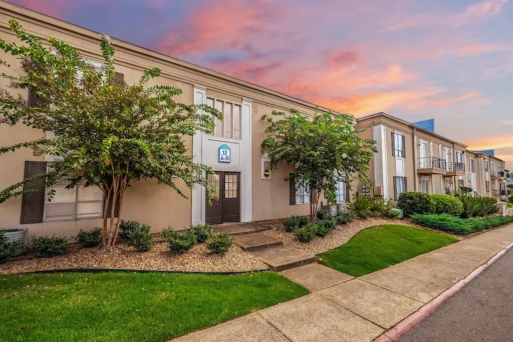 A large building with a lot of windows and trees in front of it.